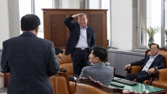 김재원 국회 예결위원장(가운데)이 1일 국회 예결위원장실에서 열린 예결위 간사 간담회에 참석하는 윤후덕 더불어민주당 간사에게 거수 경례로 인사를 하고 있다.(사진=연합뉴스)