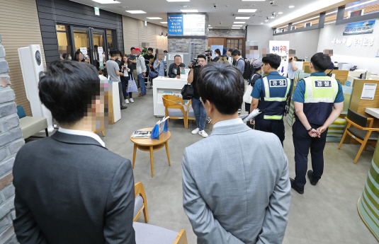 우리은행이 판매한 해외금리 연계 파생결합펀드(DLF)의 만기일인 19일 오전 경기도 성남시 우리은행 위례신도시점에서 직원들과 경찰들이 항의 방문한 투자 피해자들을 바라보고 있다. (사진=연합뉴스)