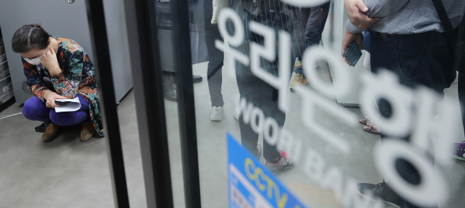 우리은행이 판매한 해외금리 연계 파생결합펀드(DLF)의 만기일인 19일 오전 경기도 성남시 우리은행 위례신도시점을 항의 방문한 투자 피해자가 주저앉아 있다. (사진=연합뉴스)