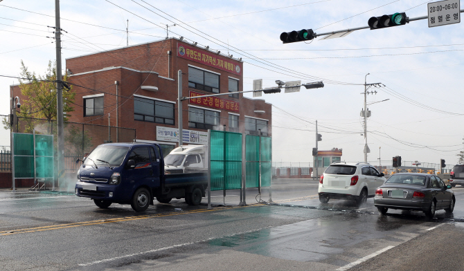 26일 아프리카돼지열병(ASF)가 확산하는 인천 강화지역에서 차량 방역작업을 진행하고 있다. 연합뉴스 제공
