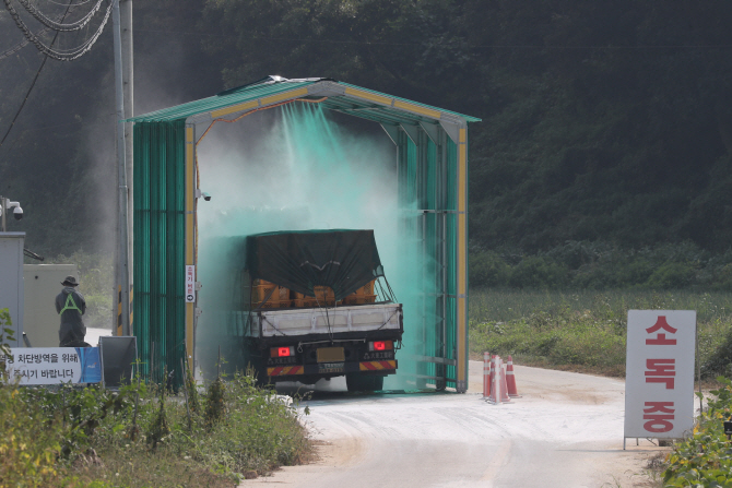 경기도 파주시 적성면 임진강 인근 거점소독시설에서 방역당국이 축산시설 출입차량을 소독하고 있다. 연합뉴스 제공