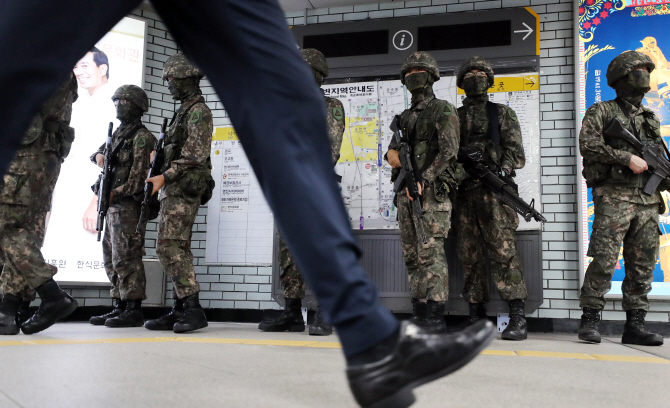서울 지하철 종각역에서 지하철 테러 대응ㆍ재난대비 훈련이 열린 지난 8월 26일 시민들이 훈련 투입을 위해 대기 중인 군병력 앞을 지나고 있다. 연합뉴스 제공