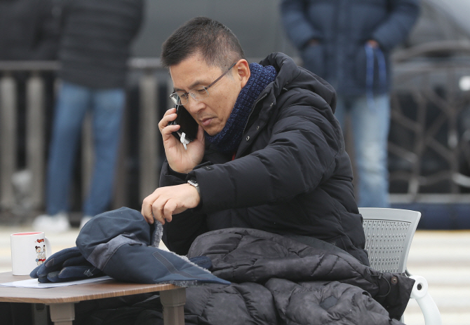 자유한국당 황교안 대표가 21일 청와대 앞 분수대 광장에서 ‘단식 투쟁’을 하던 중 전화를 하고 있다. (사진=연합뉴스)
