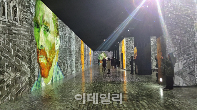 ‘빛의 벙커 반 고흐’ 전 중 한 장면. 고흐의 ‘자화상’들이 벽을 타고 흐르고 있다. 90여개 프로젝터가 토해내는 영상, 70여개 스피커가 내뿜는 음악이 만든 ‘장관’이다(사진=오현주 문화전문기자).