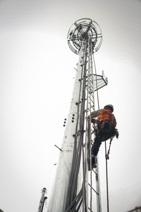 지난달 26일 경기도 구리시 ‘갈매IC지상공용기지국’ SK텔레콤 기지국 설치 현장에서 백낙균 팀장이 20미터 높이의 강관주를 오르고 있다. (사진=SK텔레콤)