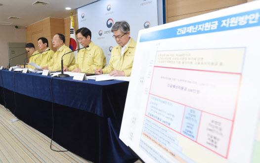 홍남기(가운데) 경제부총리 겸 기획재정부 장관이 지난달 30일 정부서울청사에서 열린 제3차 비상경제회의 결과 관계부처 합동브리핑에서 주요 내용을 발표하고 있다. 연합뉴스 제공)