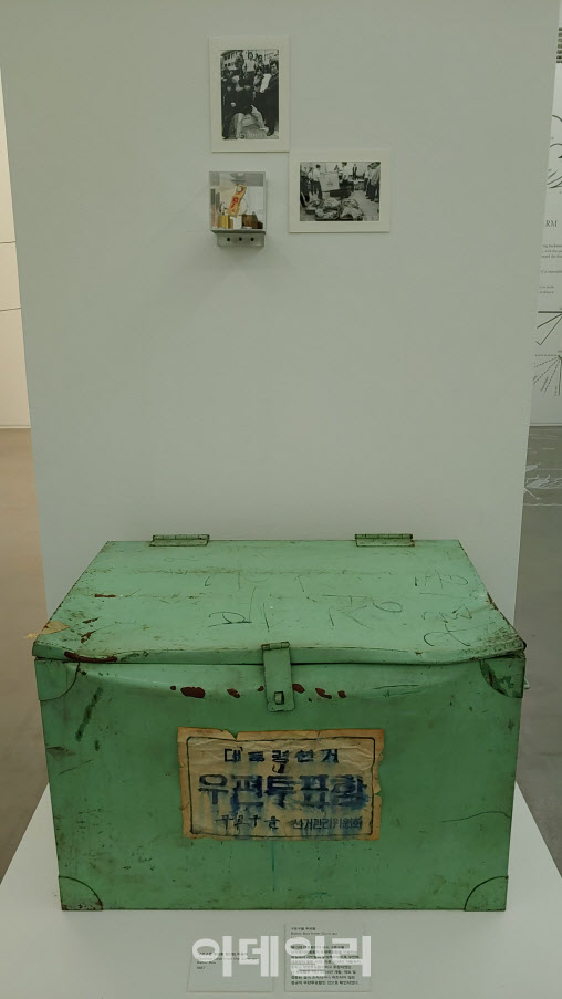 1987년 ‘제13대 대통령선거’ 때 사용했던 ‘구로구을 투표함’. 당시 서울 구로구을에서 이송하던 우편투표함을 부정투표함이라 여겼던 시민들이 막아서면서 개표를 못한 사건의 바로 그 투포함이다. 이후 2016년까지 이 함은 열리지 못했다. 위로 당시 시민들이 올라탄 채 투표함을 ‘지키던’ 자료사진, 투표함에서 절단한 자물쇠가 보인다(사진=오현주 문화전문기자).