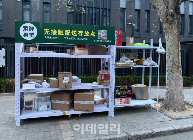 베이징의 한 아파트 앞에 비접촉 택배 및 배달상품 진열대에 물건이 놓여져 있다. 사진=신정은 특파원