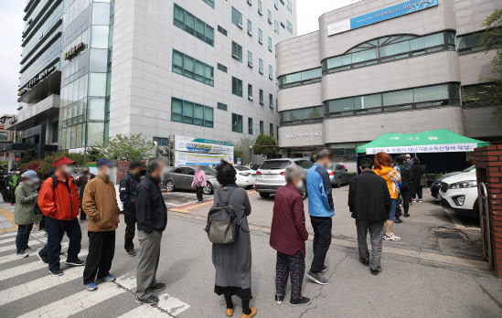 경기도가 1인당 10만원씩 지급하는 재난기본소득에 대한 현장 신청이 시작된 20일 오전 경기 수원시 매산동 행정복지센터에 마련된 접수창구 앞에 시민들이 길게 줄을 늘어서 있다.(사진=연합뉴스)