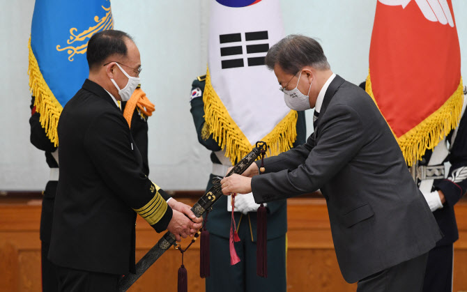 문재인 대통령이 지난 달 10일 청와대에서 부석종 해군참모총장의 진급 및 보직신고를 받은 후 삼정검(三精劍)에 수치(綬幟)를 달아주고 있다. 수치는 끈으로 된 깃발로 장성의 보직과 이름, 임명 날짜, 수여 당시 대통령 이름이 수놓아져 있다. [사진=연합뉴스]