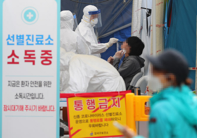 25일 서울 강서구 보건소 선별진료소에서 직원들이 시민의 검체를 채취하고 있다. (사진 = 연합뉴스 제공)