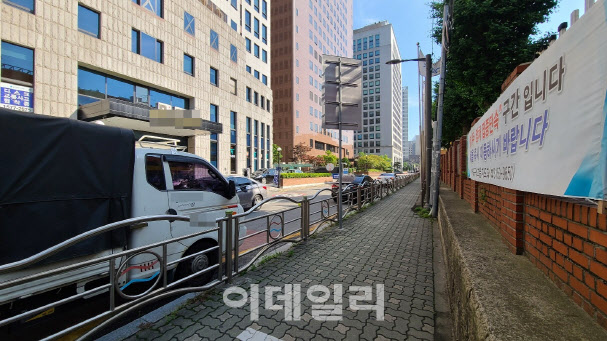 27일 오전 서울 마포구의 한 초등학교 담장 옆 도로에 한 트럭이 주차돼 있다. 이 담장엔 ‘불법 주·정차 집중단속 구간이니 차량을 즉시 이동하라’는 문구의 현수막이 걸려 있다. (사진=이용성 기자)