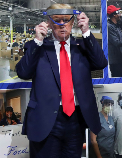 도널드 트럼프 미국 대통령이 지난 21일(현지시간) 미시간주의 포드 자동차 로슨빌 부품공장을 시찰하며 얼굴 가리개를 들어보고 있는 모습 (사진=연합뉴스)