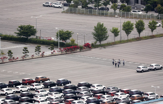 지난달 25일 오전 광주 서구 기아자동차 광주2공장이 휴업에 들어간 가운데 직원들이 비어있는 직원 주차장에서 완성차 주차장으로 향하고 있다. 연합뉴스 제공