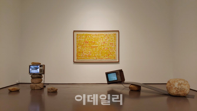 박현기의 ‘비디오 돌탑’(1978·왼쪽)과 ‘무제’(TV시소·1984/2016) 뒤로 회화 ‘무제’(1993∼1994)가 걸렸다. 박현기는 돌·나무·흙 등에 TV·거울·유리 등을 병치해 관념적이고 독보적인 한국의 비디오아트세계를 열고 이끌었다(사진=오현주 문화전문기자).
