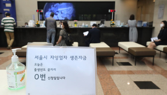 지난달 서울 한 시중은행에 ‘서울시 생존자금’ 신청 접수 안내문구가 놓여 있다.(연합뉴스 제공)