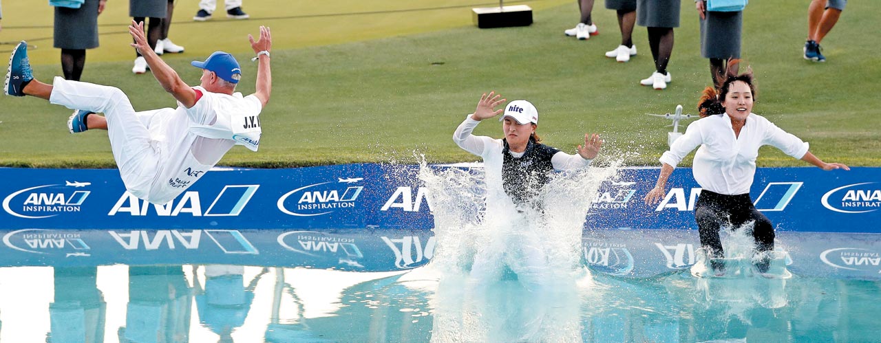 한국선수 5번째 '호수의 여인' - 고진영(가운데)이 8일 미국여자프로골프 투어 ANA인스퍼레이션 우승을 확정 지은 뒤 대회 전통에 따라 랜초 미라지 미션힐스컨트리클럽 18번 홀 옆에 있는 연못 '포피스 폰드'에 캐디 데이비드 브루커(왼쪽), 에이전트 최수진(오른쪽)과 함께 뛰어들고 있다. /게티이미지 연합뉴스