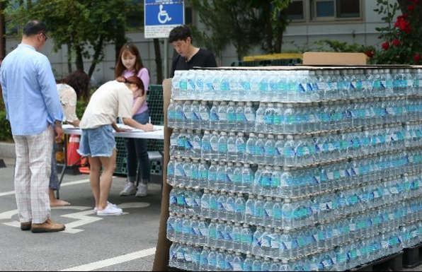 붉은 수돗물이 나온 인천 서구의 한 주민센터에서 시민들이 생수병을 받기 위해 서명하고 있는 모습./조선일보 DB