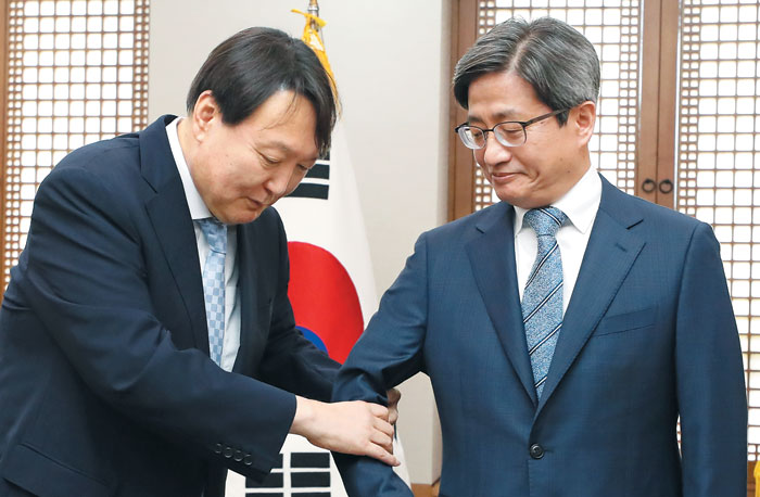 대법원장 찾아간 검찰총장 - 26일 서울 서초구 대법원 청사에서 윤석열(왼쪽) 신임 검찰총장이 김명수 대법원장과 함께 기념촬영을 준비하며 김 대법원장의 팔을 잡아 끌고 있다. 취임 다음날인 이날 윤 총장은 김 대법원장을 예방했다. 2분여간 환담을 나눈 두 사람은 기념사진 촬영 후 비공개로 대화했다. /연합뉴스