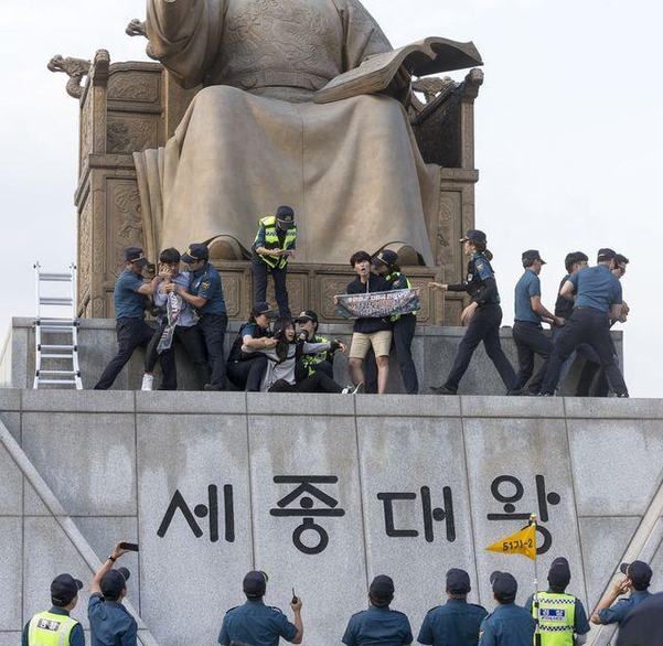 한국대학생진보연합이 지난 4일 서울 광화문광장 세종대왕 동상에 올라 지소미아 파기 방해, 미국 규탄 기습시위 중 경찰에 연행되고 있다. /김지호 기자