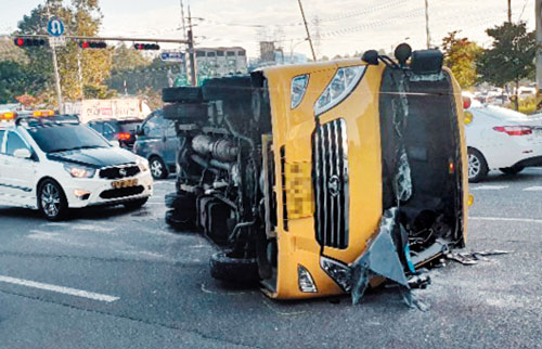25일 오전 서울 송파구 방이동에서 고등학교 통학버스가 다른 차량과 충돌해 전복돼 있다. /연합뉴스