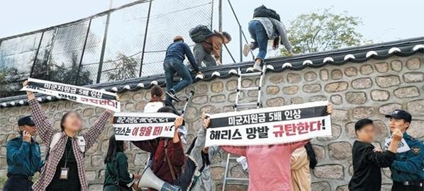 지난달 18일 오후 3시쯤 한국대학생진보연합 회원들이 서울 중구 정동 주한 미국대사관저 담장에 사다리를 대고 관저 안으로 넘어 들어가고 있다. /뉴시스