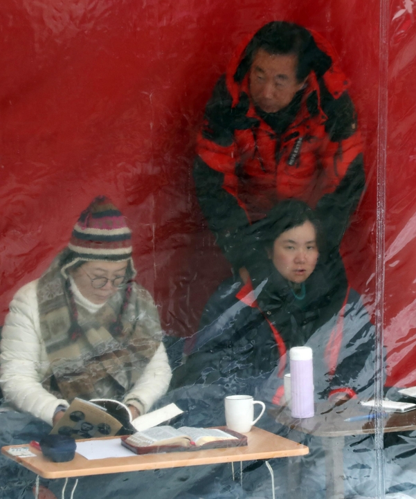 자유한국당 정미경(왼쪽), 신보라(오른쪽 아래) 최고위원이 1일 오전 청와대 앞에서 선거법·공수처법 철회 요구 단식 농성중인 가운데 단식 경험이 있는 김성태 한국당 의원이 신 의원의 어깨를 주물러주고 있다./연합뉴스
