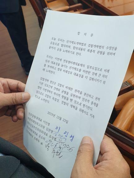 대안신당 유성엽 창당준비위원장이 23일 오후 국회에서 4+1 협의체의 '선거법·검찰개혁법' 합의문을 보여주고 있다. 더불어민주당 이인영 원내대표, 바른미래당 김관영 최고위원, 대안신당 유 창당준비위원장, 정의당 윤소하 원내대표, 민주평화당 조배숙 원내대표를 대리한 박주현 의원의 서명이 담겨있다. /연합뉴스