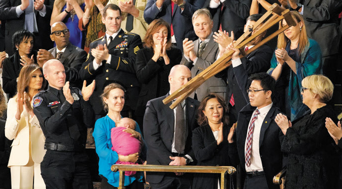2018년 1월 30일(현지 시각) 탈북 인권 운동가 지성호씨가 미국 워싱턴 의회에서 열린 도널드 트럼프 대통령의 신년 국정연설회에 초청받았다. 지씨가 목발을 들어 올리자 청중들이 박수를 치고 있다. /연합뉴스