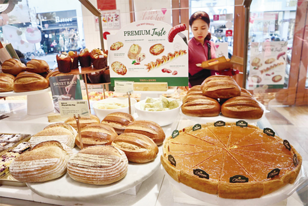 젊은 베트남 여성이 호찌민 하이바쯩 거리에 있는 뚜레쥬르 베트남 1호점 매장에서 빵을 고르고 있다. CJ푸드빌이 운영하는 뚜레쥬르는 진출 초기 어려운 여건 속에서도 ‘프리미엄’ 전략을 고집해 고급 베이커리 카페로 자리매김했다. /이용성 기자