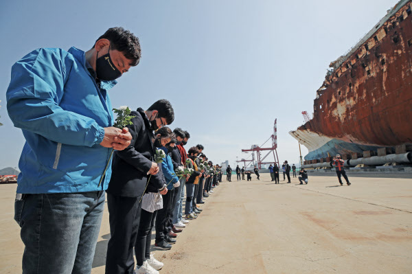 16일 오후 세월호 희생자 유가족, 4·16 재단 관계자 등이 전남 목포시 목포신항만에 인양된 세월호에 헌화하기 전 묵념하고 있다. /연합뉴스