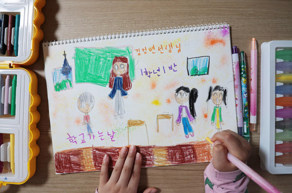 2차 등교를 하루 앞둔 26일 서울 용산구의 한 초등학교 1학년 학생이 내일 처음 만날 선생님을 만나는 광경을 그림으로 표현하고 있다./이태경기자