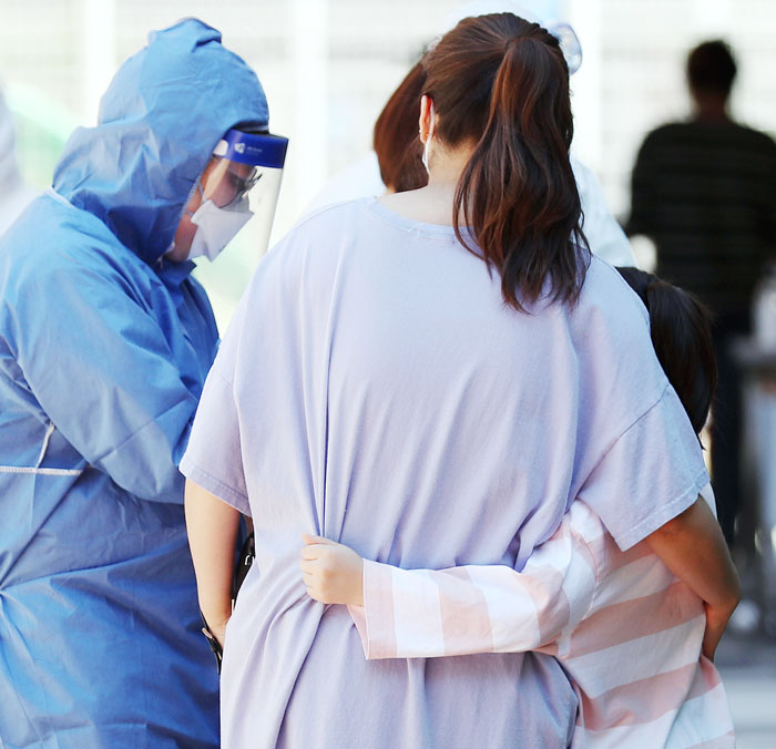 코로나 검사 무서워… 엄마 꼭 껴안은 아이 - 29일 오후 인천시 서구 백석초등학교에서 한 학생이 교내에 마련된 선별진료소에서 코로나 검사를 받기 직전 엄마를 꼭 껴안고 있다. 이 학교는 이날 교사 1명이 코로나 확진 판정을 받으면서 전교생의 등교를 중지시켰고, 방역 당국은 교직원과 학생 400여 명에 대한 전수 검사에 착수했다. /연합뉴스