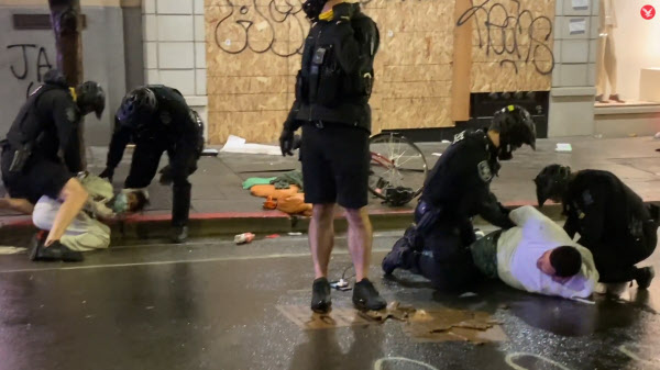 지난달 31일(현지 시각) 미국 시애틀에서 벌어진 조지 플로이드 관련 시위에서 한 경찰관(왼쪽에서 두 번째)이 시위대(흰 옷) 체포 과정에서 시위대의 목을 무릎으로 짓누르고 있다. /트위터 영상 캡처