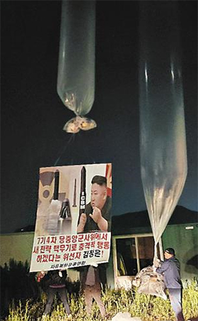 자유북한운동연합 회원들이 지난달 31일 새벽 경기 김포시 월곶면 일대에서 ‘새 전략 핵무기로 충격적 행동 하겠다는 위선자 김정은’이라는 문구가 적힌 플래카드와 대북 전단을 대형 풍선에 달아 북한으로 날려 보내고 있다. /자유북한운동연합