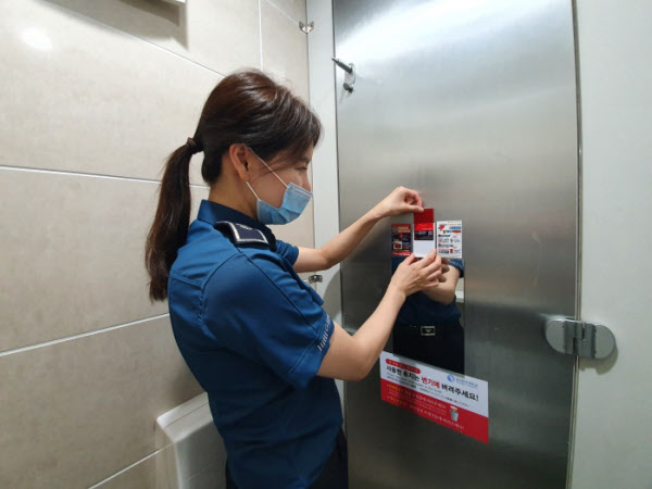 서울 성북경찰서 직원이 관내 화장실에 불법카메라 간이점검 카드와 안내문을 설치하고 있다./성북경찰서