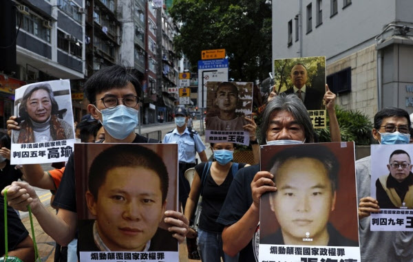 홍콩 시위대가 25일 중국에 구금된 민권운동가ㆍ변호사 등의 사진을 들고 홍콩보안법 철회를 요구하며 거리행진을 하고 있다. /AP 연합뉴스