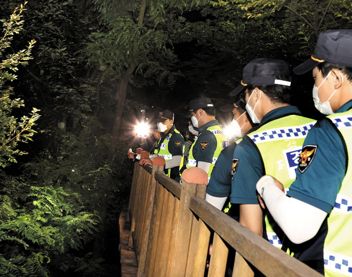 박원순 서울시장의 연락 두절 소식이 알려진 9일 밤 경찰들이 손전등을 들고 서울 종로구 와룡공원 인근에서 수색 작업을 벌이고 있다. 박 시장은 이날 오전 10시 44분 종로구 가회동 공관을 나섰으며, 13시간쯤 뒤 북악산 숙정문 근처에서 숨진채 발견됐다. /오종찬 기자