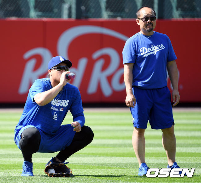 [OSEN=이동해 기자] 류현진이 김용일 트레이너와 스트레칭 후 목을 축이고 있다. / eastsea@osen.co.kr