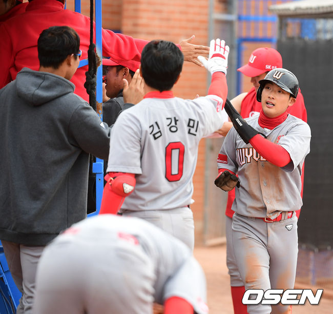 [OSEN=투산(미국 애리조나주), 지형준 기자]SK 최지훈이 득점에 성공하며 동료선수들과 하이파이브를 하고 있다. /jpnews@osen.co.kr