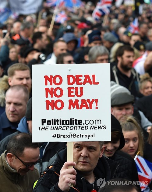 "노 딜, 노 EU, 노 메이"(런던 EPA=연합뉴스) 9일(현지시간) 영국 런던 중심가에서 열린 극우 영국독립당(UKIP) 지지자들의 브렉시트(영국의 EU 탈퇴) 촉구 집회에서 한 참가자가 '노 딜, 노 EU, 노 메이' 문구가 쓰인 손팻말을 들고 있다. ymarshal@yna.co.kr