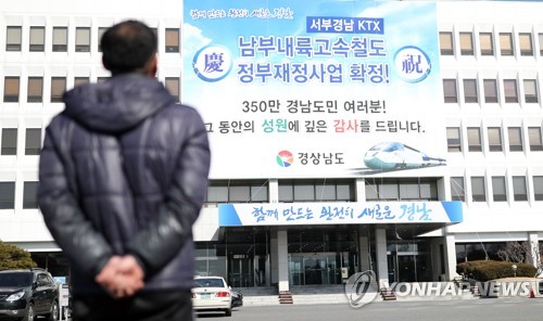 경남도 예타면제 환영(창원=연합뉴스) 김동민 기자 = 정부가 국가균형발전위원회와 국무회의를 열어 의결한 예비타당성 조사 면제사업 대상에 서부경남KTX가 포함된 29일 창원시 의창구 경남도청 입구에 이를 환영하는 대형 펼침막이 걸려있다.
서부경남KTX(남부내륙고속철도) 사업은 문재인 대통령과 김경수 경남도지사가 선거 과정에서 내놓은 공약으로 경북 김천에서 경남 합천·진주·고성·통영·거제를 잇는 191.1㎞ 고속철도 노선으로 수도권과 남해안이 2시간대에 연결된다. 서울 기준으로 현재 거제까지 4시간 30분 걸리던 것이 2시간 30분으로 줄어든다. 2019.1.29 image@yna.co.kr