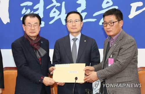 제명 촉구 서한 전달받는 홍영표(서울=연합뉴스) 하사헌 기자 = 더불어민주당 홍영표 원내대표(가운데)가 13일 오후 국회를 방문한 5.18 단체 관계자들로부터 '5.18망언 의원' 제명을 촉구하는 서한을 전달받고 있다.  toadboy@yna.co.kr