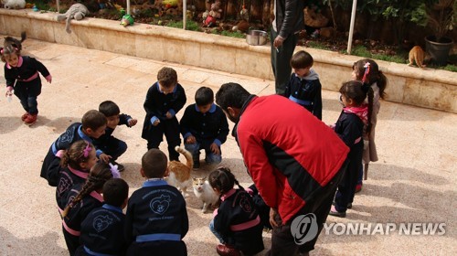 2018년 시리아 알레포에 있는 고양이 보호소에서 유치원 어린이들과 알잘릴이 고양이와 함께 노는 모습 [EPA=연합뉴스]