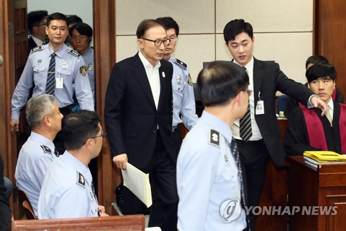 법정 들어오는 이명박 전 대통령(서울=연합뉴스) 한상균 기자 = 뇌물수수와 다스 횡령 등 혐의로 구속기소 된 이명박 전 대통령이 23일 오후 서울중앙지법에서 열린 첫 공판에 출석하기 위해 법정으로 들어서고 있다.  2018.5.23 xyz@yna.co.kr