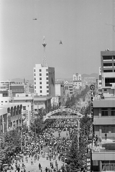 금남로에서 시위하는 광주시민들 위로 떠다니는 육군 공격헬기 500MD와 기동헬기 UH-1H(사진 = 나경택 기자)