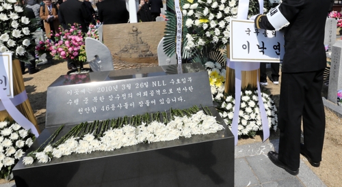 바닥에 있다가 다시 붙는 '총리 명판'(대전=연합뉴스) 이재림 기자 = 22일 대전 유성구 국립대전현충원 천안함 46용사 묘역에서 한 장병이 이낙연 총리 화환 명판을 달고 있다. 이 장병은 '저 명판은 원래 저기 있었다'고 귀띔한 자유한국당 대전시당 관계자 말을 듣고 바닥에 있던 명판을 제자리에 붙였다. 2019.3.22