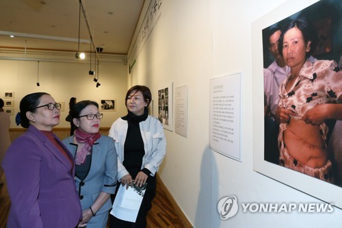 베트남전 한국군 학살 기록전 찾은 피해자(광주=연합뉴스) 천정인 기자 = 3일 오후 광주 서구 5·18기념문화센터에서 열린 한국군의 민간인학살을 기록한 전시회에 베트남 피해자인 응우옌티탄(왼쪽)이 자신의 사진을 보고 있다. 2019.4.3 iny@yna.co.kr