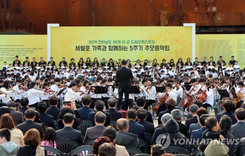 세월호 앞에서 추모음악회(목포=연합뉴스) 박철홍 기자 = 세월호 5주기를 며칠 앞둔 12일 오후 전남 목포신항에 거치된 세월호 앞에서 전남 20개 시군의 드림오케스트라 1천명 어린이 단원이  4·16합창단과 함께 추모음악회를 개최하고 있다. 2019.4.12 pch80@yna.co.kr