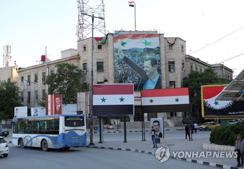 아사드 대통령의 사진과 국기가 걸린 시리아 북부 알레포 거리      [타스=연합뉴스 자료사진]